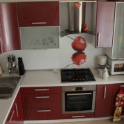 Угловая красная кухня - фото интерьера