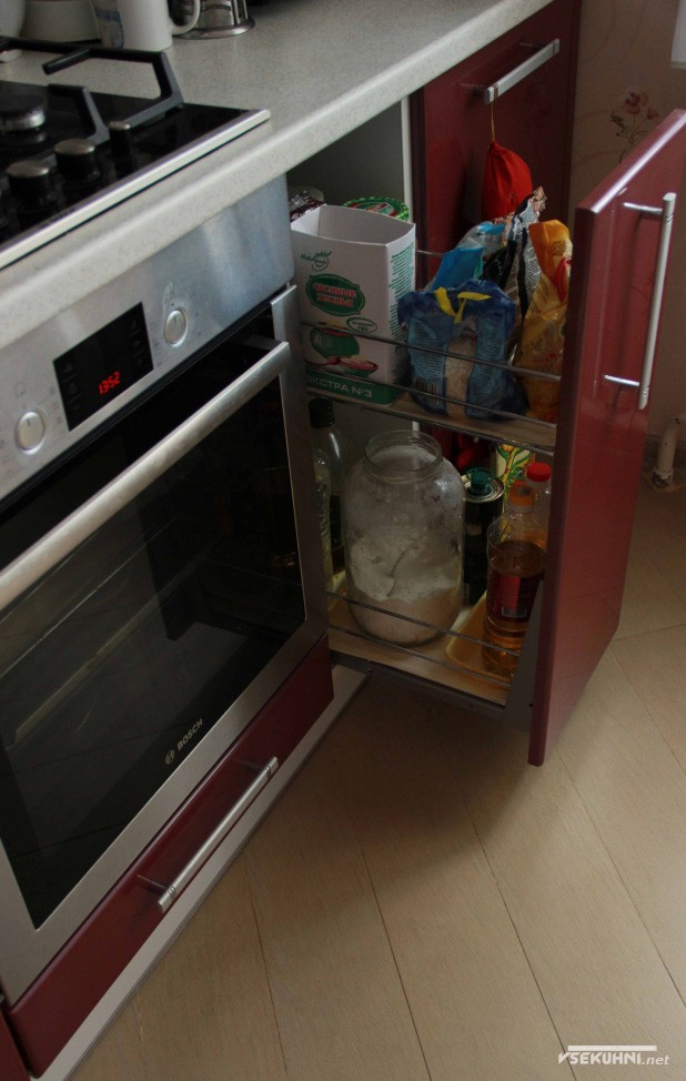 Выдвижной кухонный ящик на кухне красного цвета - фото